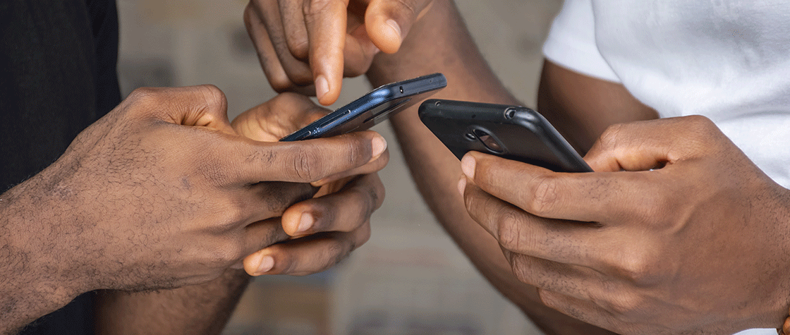 two men comparing information on their smartphones