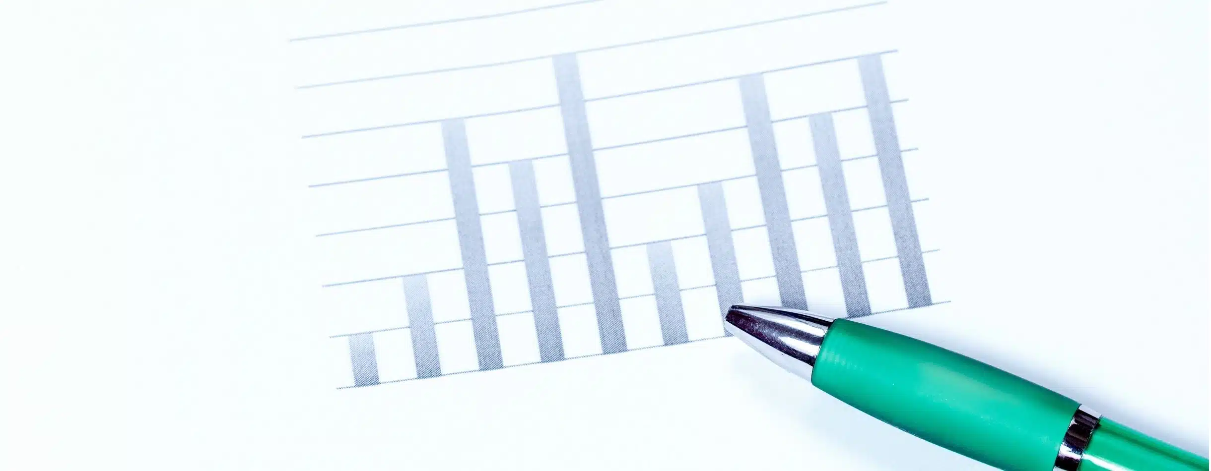 A pen is laid on a piece of paper depicting a bar chart
