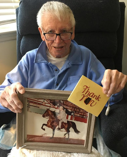 This is an example of an excellent nonprofit story told through email. This image shows a man who has white hair and glasses holding up an old photo of himself training a horse, along with a thank-you note.