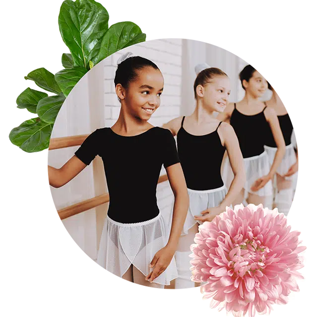 YMCA dance lessons showing three kids in ballerina shirts and pants standing up against a wooden rale smiling.